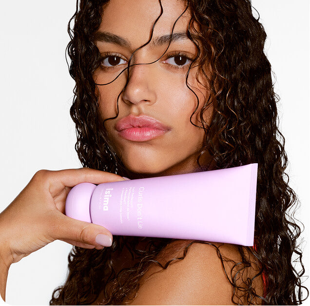 Woman holding a purple hair product with a white background