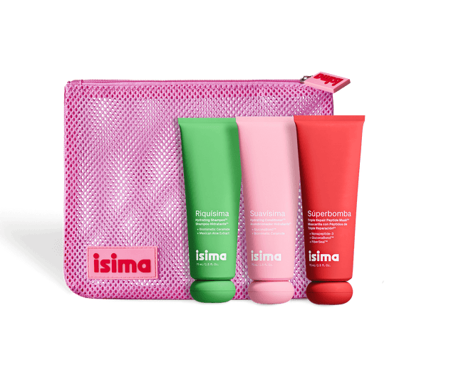 Three colorful isima tubes (green, pink, red) stand before a matching pink mesh pouch—all part of Shakira's Starter Trio — Strength & Repair ($67 value) by isima—perfect for skincare-inspired routines and healthy-looking hair.