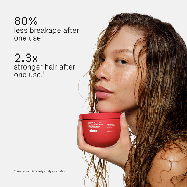 Woman with wet hair holds isima Shakira’s Súperbomba Set jar. Text: 80% less breakage, 2.3x stronger hair after one use—even for damaged hair.